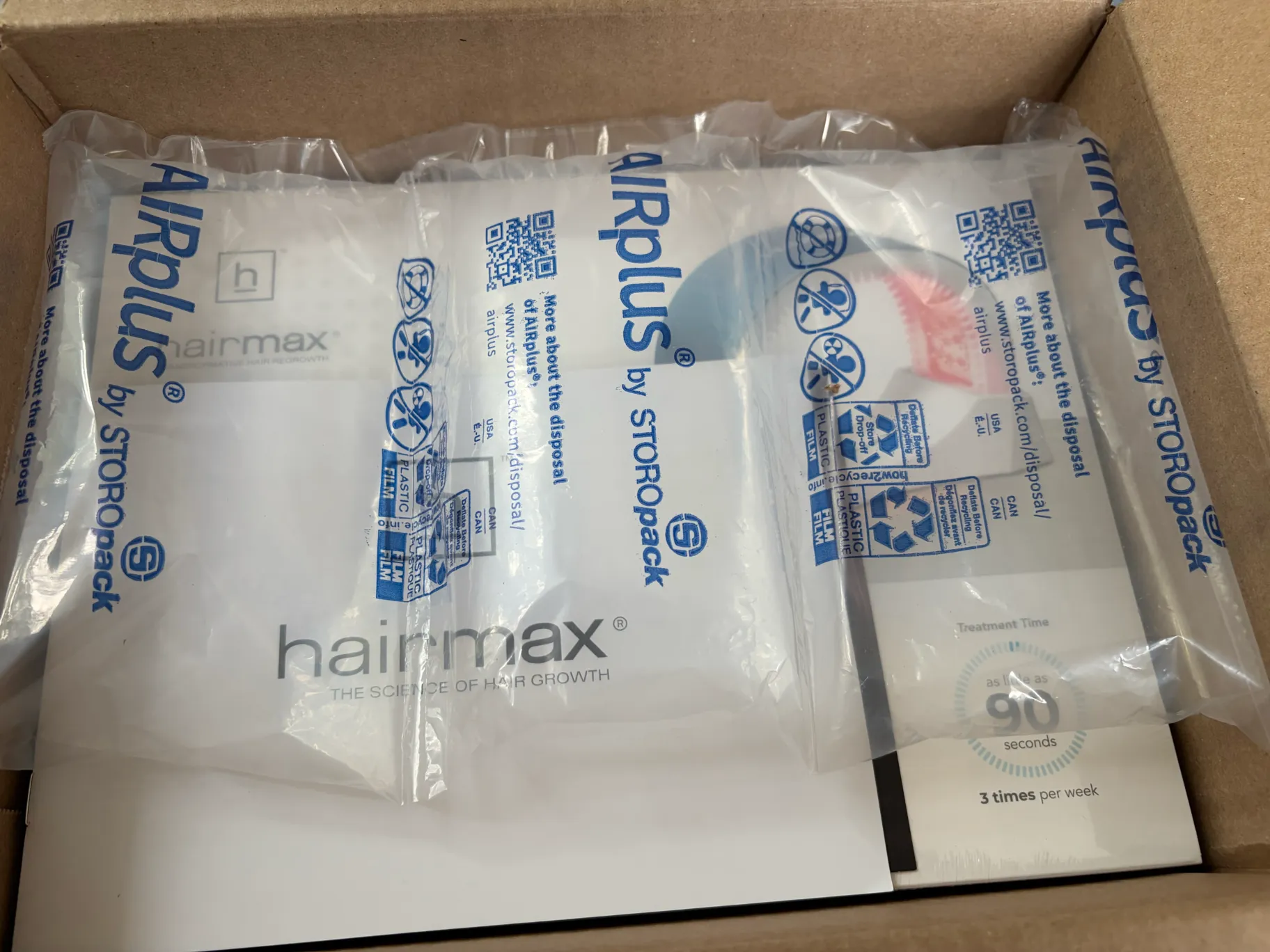 段ボールの中で緩衝材に包まれたヘアマックスの商品箱